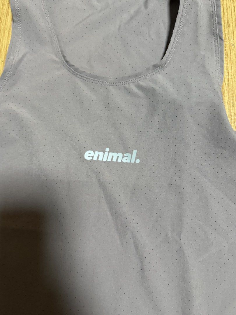 enimal perforated gym workout tank top mink (Category: Activewear) located in Angeles City. Submitted by reginageorge22 (Listing ID 1465288580, Image 2). Description: Enimal athletic tank top in a dusty purple shade (mink - soldout color) Used once. Lightweight perforated fabric keeps you cool during workouts. Small 'enimal.' logo printed on the chest, plus a woven brand patch near the lower hem. Round neckline and sleeveless cut. Back features a