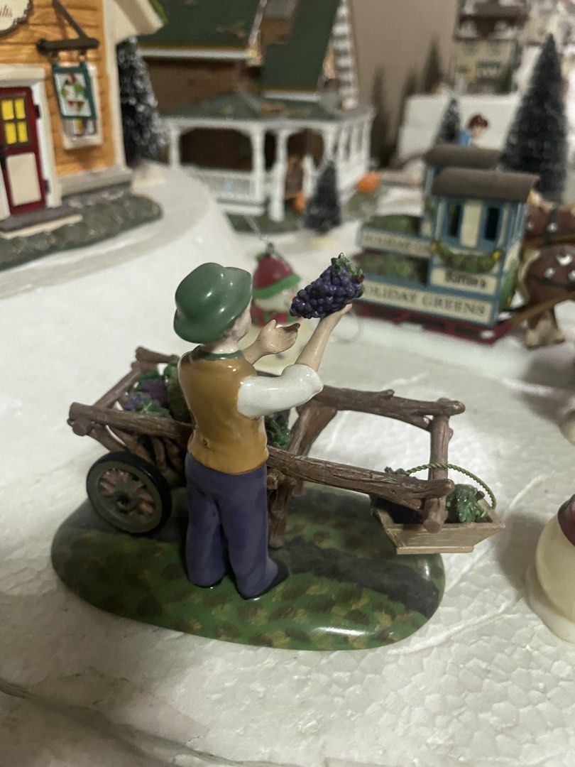 Department 56 Fall Figurines (Category: Figurines & Statues) located in Quezon City. Submitted by inamocha (Listing ID 1465373476, Image 2). Description: - Piece 1: Man holding grapes next to a wooden wheelbarrow filled with grapes (1500) - Piece 2: Children building a scarecrow with a carved pumpkin head on a hay bale (1500) - Hand-painted details with autumn leaves on the base - Ideal for holiday setups, miniature villages, and seasonal home de