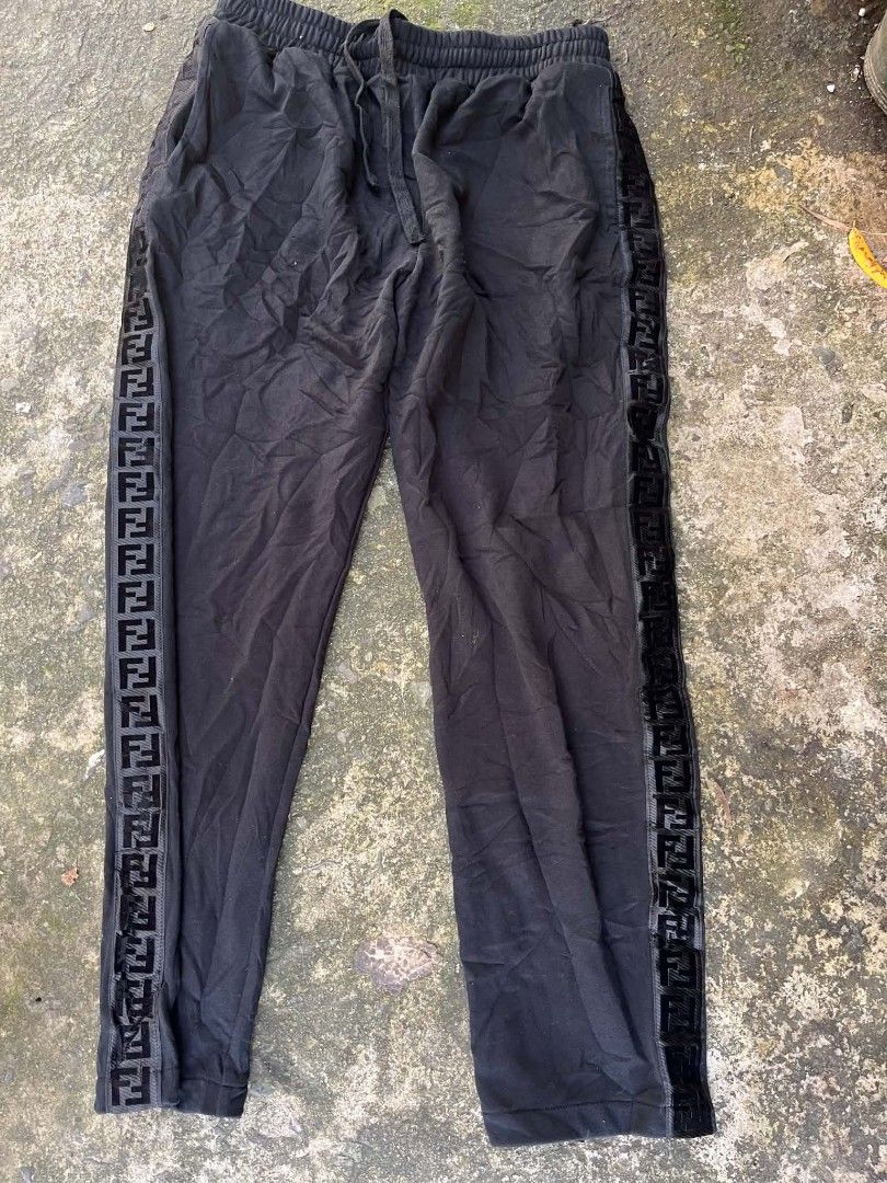 Fendi Black Jogger Pants with FF Side Tape (Category: Joggers) located in Manila. Submitted by sls.wear (Listing ID 1465206738, Image 1). Description: Fendi sweatpants in black. Elastic waistband with drawstring closure. Features FF logo tape down both side legs. Zippered pockets near the waist. Made in Italy, size 50. 100% cotton material. Interior brand tags and care label attached..