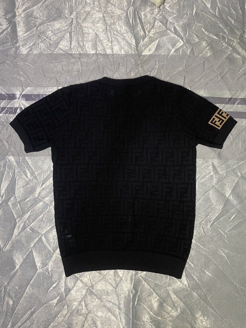 Fendi FF Monogram Knit Short Sleeve Top Black (Category: Shirts) located in San Fernando. Submitted by theglobalgoods (Listing ID 1465234378, Image 2). Description: Black Fendi short sleeve knit top in 100% cotton. Size small, style code FY0636T3J. All-over textured FF monogram pattern with contrast brown logo patches on the hem and right sleeve. Ribbed crewneck, cuffs, and hem..