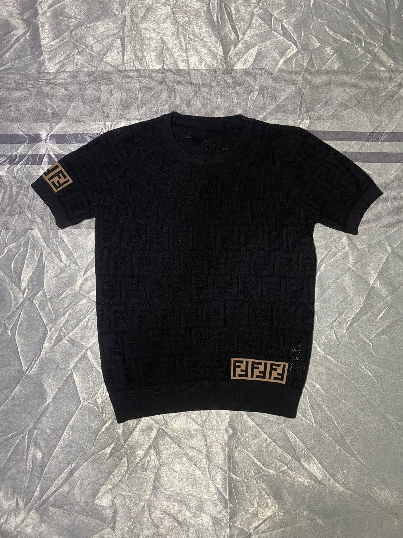 Fendi FF Monogram Knit Short Sleeve Top Black (Category: Shirts) located in San Fernando. Submitted by theglobalgoods (Listing ID 1465234378, Image 1). Description: Black Fendi short sleeve knit top in 100% cotton. Size small, style code FY0636T3J. All-over textured FF monogram pattern with contrast brown logo patches on the hem and right sleeve. Ribbed crewneck, cuffs, and hem..