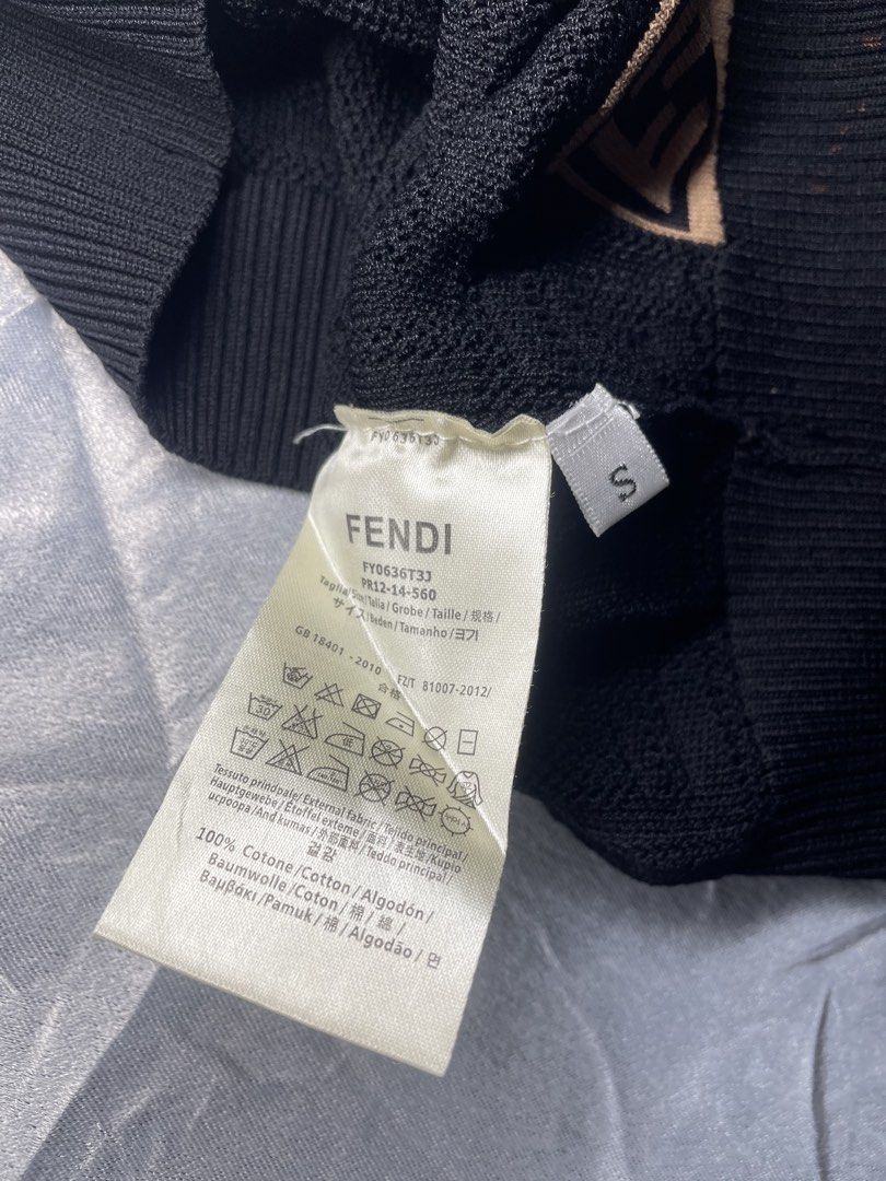 Fendi FF Monogram Knit Short Sleeve Top Black (Category: Shirts) located in San Fernando. Submitted by theglobalgoods (Listing ID 1465234378, Image 3). Description: Black Fendi short sleeve knit top in 100% cotton. Size small, style code FY0636T3J. All-over textured FF monogram pattern with contrast brown logo patches on the hem and right sleeve. Ribbed crewneck, cuffs, and hem..