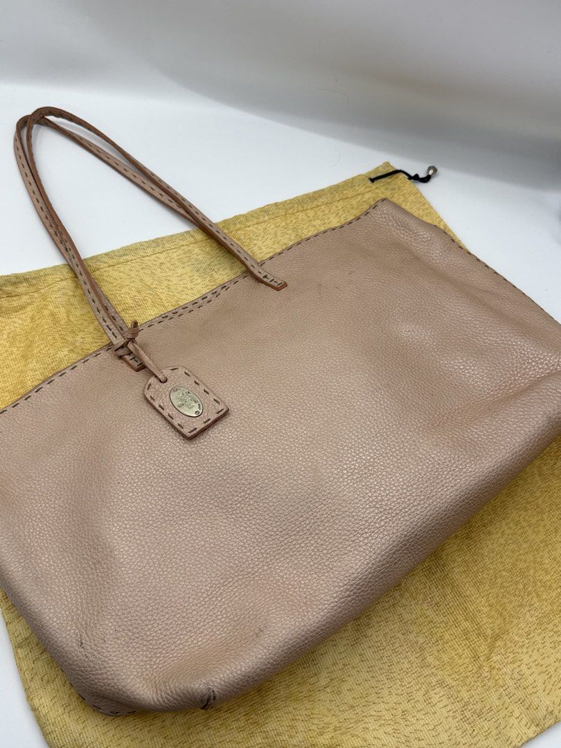 Fendi totebag (Category: Tote Bags) located in Caloocan City. Submitted by rossvault2 (Listing ID 1465231411, Image 3). Description: - Authentic Fendi Selleria tote bag in textured pink leather - Double shoulder straps with elegant contrast stitching - Hanging leather tag featuring the iconic metal Fendi Selleria plaque - Spacious interior with a zip pocket, authentic hologram tag, and serial number strip - Includes original matching yellow Fendi