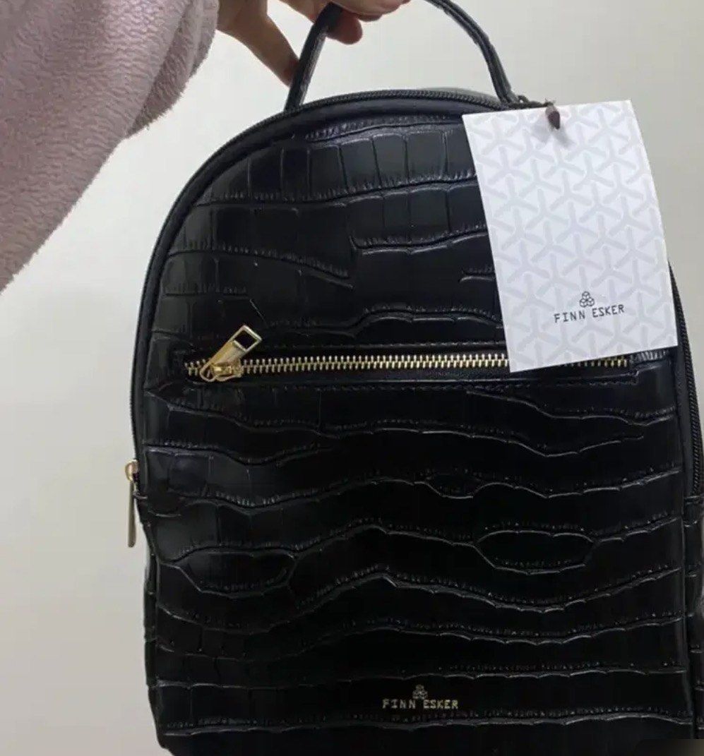 Finn Esker Black Crocodile Pattern Mini Backpack (Category: Backpacks) located in Manila. Submitted by lynnalec25 (Listing ID 1465362574, Image 3). Description: - Brand: Finn Esker - Condition: Brand new with original tag attached - Material/Design: Black backpack with a glossy crocodile embossed pattern - Hardware: Elegant gold-tone zippers, including a convenient front pocket - Comfort & Carry: Features a sturdy top handle and adjustable should