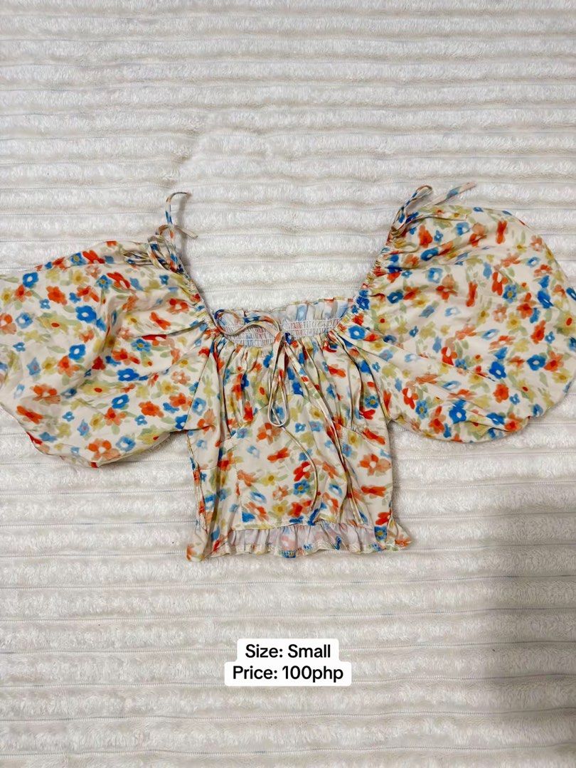 Floral Print Puff Sleeve Crop Top (Category: Blouses) located in Pasig City. Submitted by jamie.sebuc (Listing ID 1465237732, Image 1). Description: - Size: Small - Design: Multi-color floral print on off-white fabric - Features: Big puff sleeves, square neckline with center tie strings, smocked bodice, and ruffled hem - Price: 100 PHP - Condition: Good as new / Ready to ship.