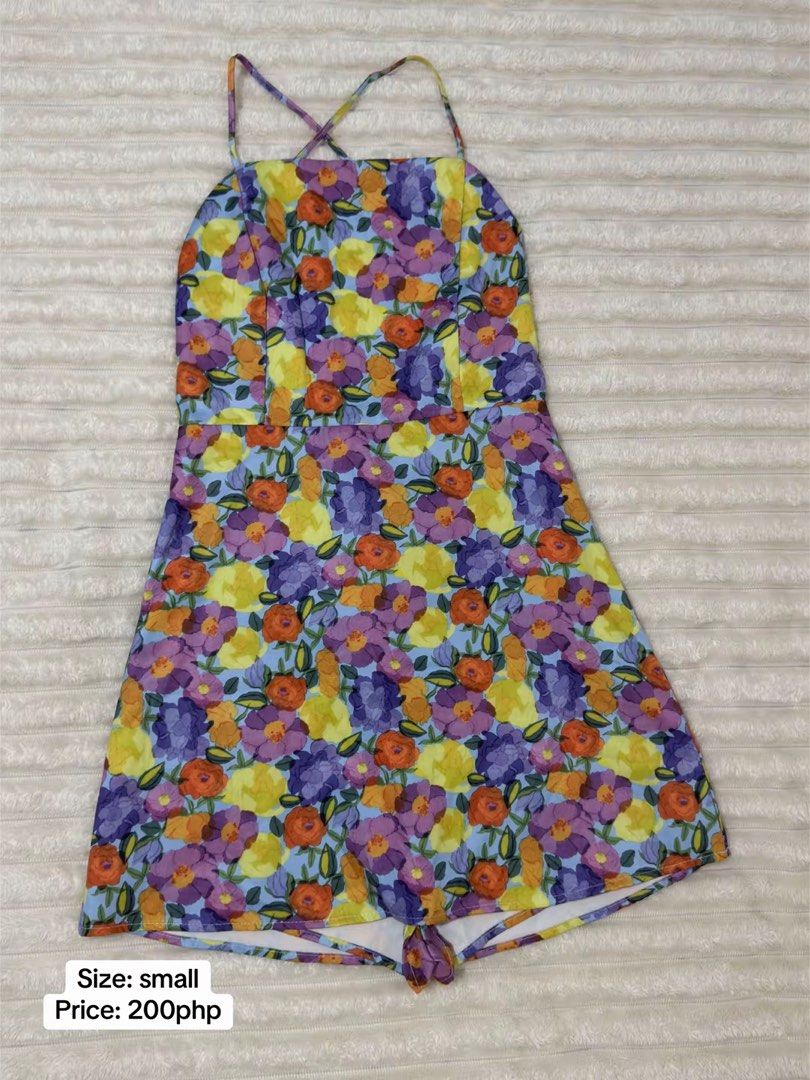 Floral Print Romper Size Small (Category: Rompers) located in Pasig City. Submitted by jamie.sebuc (Listing ID 1465237741, Image 1). Description: - Size: Small - Price: ₱200 - Design: Light blue base with purple, yellow, and orange floral print - Features: Square neckline, cross-back spaghetti straps, shorts style bottom - Condition: Great find, perfect for sunny days!.