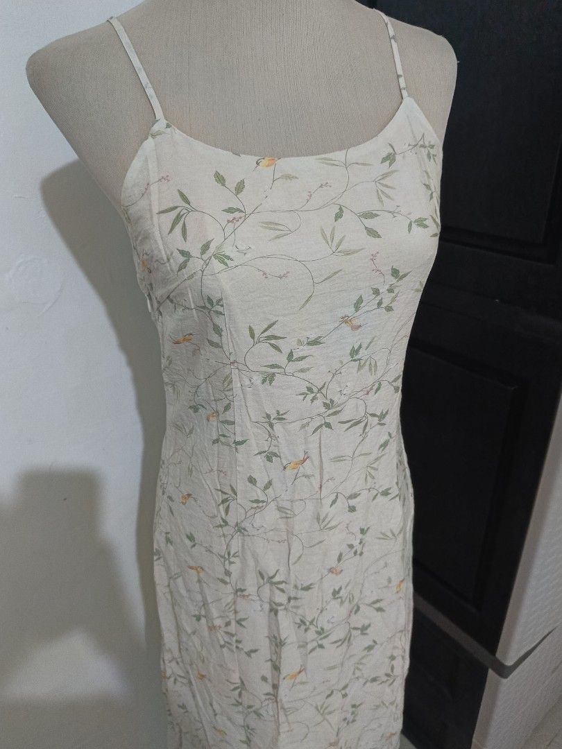 Floral spaghetti strap midi dress (Category: Dresses) located in Cabanatuan. Submitted by lyxyx (Listing ID 1465308556, Image 2). Description: - Style: Cream midi dress with green leaf vines and orange bird print - Design: Straight neckline with thin spaghetti straps - Length: Mid-calf - Fabric: Lightweight and breathable, great for warm weather - Versatility: Perfect for brunch dates, vacations, or casual days out - Pairing: Easy to style with s