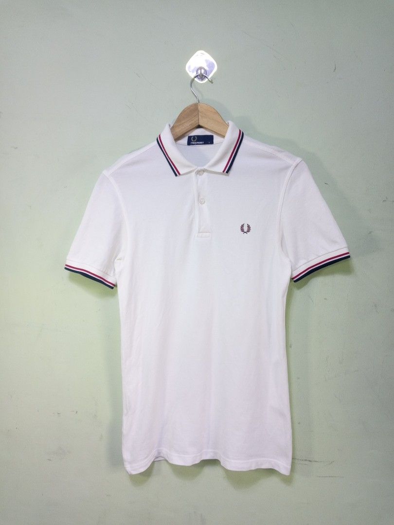 Fred Perry White Polo Shirt Size S (Category: Tshirts & Polo Shirts ) located in Manila. Submitted by onewikstraight (Listing ID 1465362856, Image 1). Description: - Brand: Fred Perry - Style: Classic polo shirt with blue and red tipped collar and cuffs - Color: White with burgundy embroidered laurel wreath logo - Size: S (Standard blue neck label) - Material: 100% cotton pique fabric - Details: Branded buttons pm 📨📥 1300+sf.