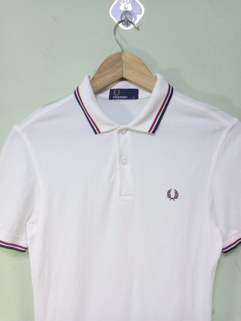 Fred Perry White Polo Shirt Size S (Category: Tshirts & Polo Shirts ) located in Manila. Submitted by onewikstraight (Listing ID 1465362856, Image 2). Description: - Brand: Fred Perry - Style: Classic polo shirt with blue and red tipped collar and cuffs - Color: White with burgundy embroidered laurel wreath logo - Size: S (Standard blue neck label) - Material: 100% cotton pique fabric - Details: Branded buttons pm 📨📥 1300+sf.