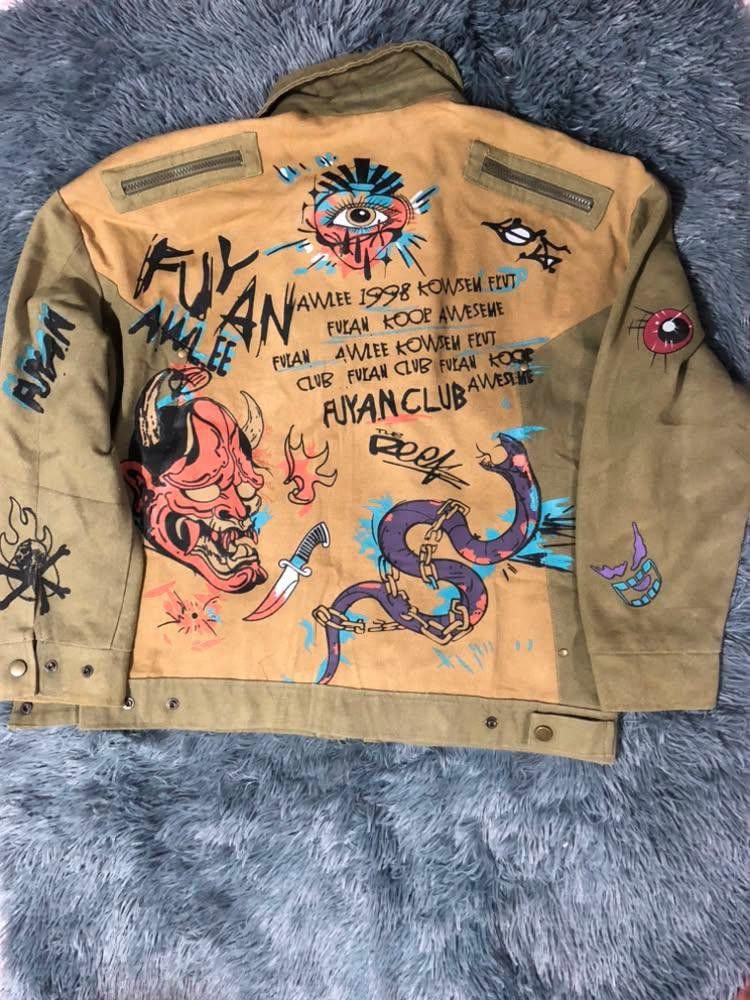 Fuyan Club Graffiti Graphic Print Jacket (Category: Coats, Jackets and Outerwear) located in Malabon City. Submitted by matcha_frappe (Listing ID 1465296764, Image 2). Description: - Color: Tan - Style: Bold streetwear jacket with heavy custom graffiti prints on front and back - Design details: Skull designs, Oni mask, snake graphic, and 'Fuyan Club 1998' typography - Features: Zip-up front, structured collar, and snap button adjustments at the w