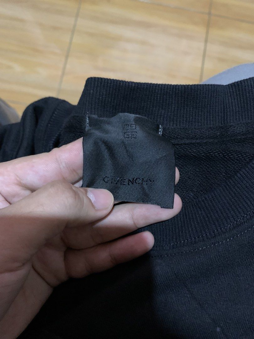 Givenchy Cat Graphic Black Sweatshirt Size M (Category: Coats, Jackets and Outerwear) located in Davao. Submitted by sadthrift (Listing ID 1465183353, Image 2). Description: - Brand: Givenchy - Color: Black - Size: M (Oversized fit) - Material: 100% Cotton, Made in Portugal - Design: Bold cat face graphic print with logo branding accents - Details: Ribbed cuffs, collar, and hem; long sleeves - Condition: Brand tags and wash care label intact.