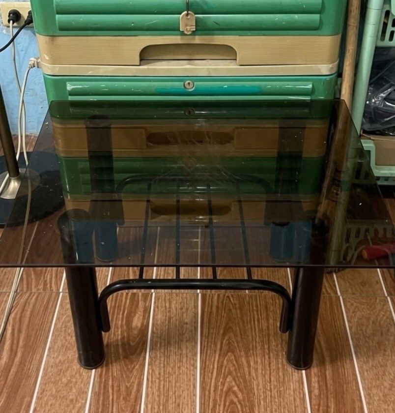 GLASS-TOP COFFEE TABLE (Category: Tables & Sets) located in San Pedro. Submitted by inyigomcclear (Listing ID 1465277579, Image 1). Description: - Modern and simple square glass top side table - Sturdy black metal frame with a convenient lower shelf rack - Sleek dark tinted glass surface - Compact design, perfect for small living spaces - Ideal as a bedside table or sofa side table.