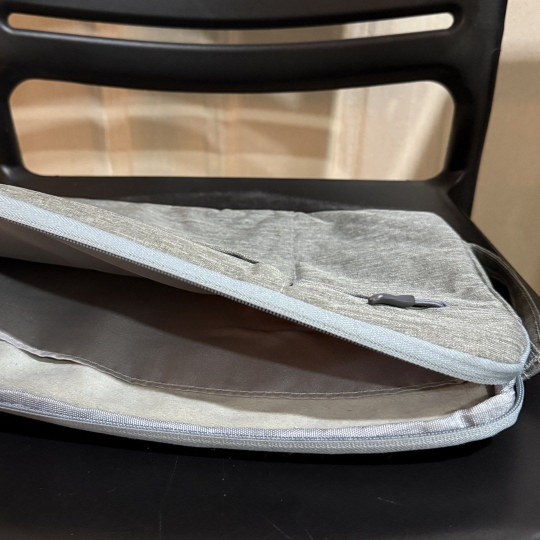 Grey Laptop Sleeve with Side Pockets and Handle (Category: Laptop Bags & Sleeves) located in Makati City. Submitted by julyco. (Listing ID 1465358030, Image 2). Description: - Color/Material: Grey textured fabric - Protection: Soft plush-lined main compartment prevents scratches - Storage: 3 zippered outer front pockets for accessories - Portability: Convenient side grab handle - Hardware: Smooth zippers with pull tabs - Condition: Clean interior