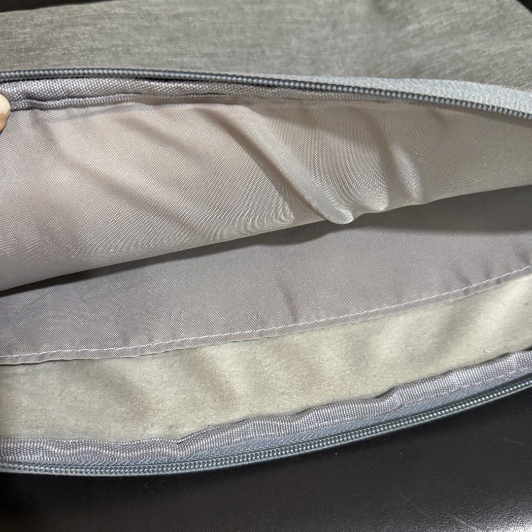 Grey Laptop Sleeve with Side Pockets and Handle (Category: Laptop Bags & Sleeves) located in Makati City. Submitted by julyco. (Listing ID 1465358030, Image 3). Description: - Color/Material: Grey textured fabric - Protection: Soft plush-lined main compartment prevents scratches - Storage: 3 zippered outer front pockets for accessories - Portability: Convenient side grab handle - Hardware: Smooth zippers with pull tabs - Condition: Clean interior
