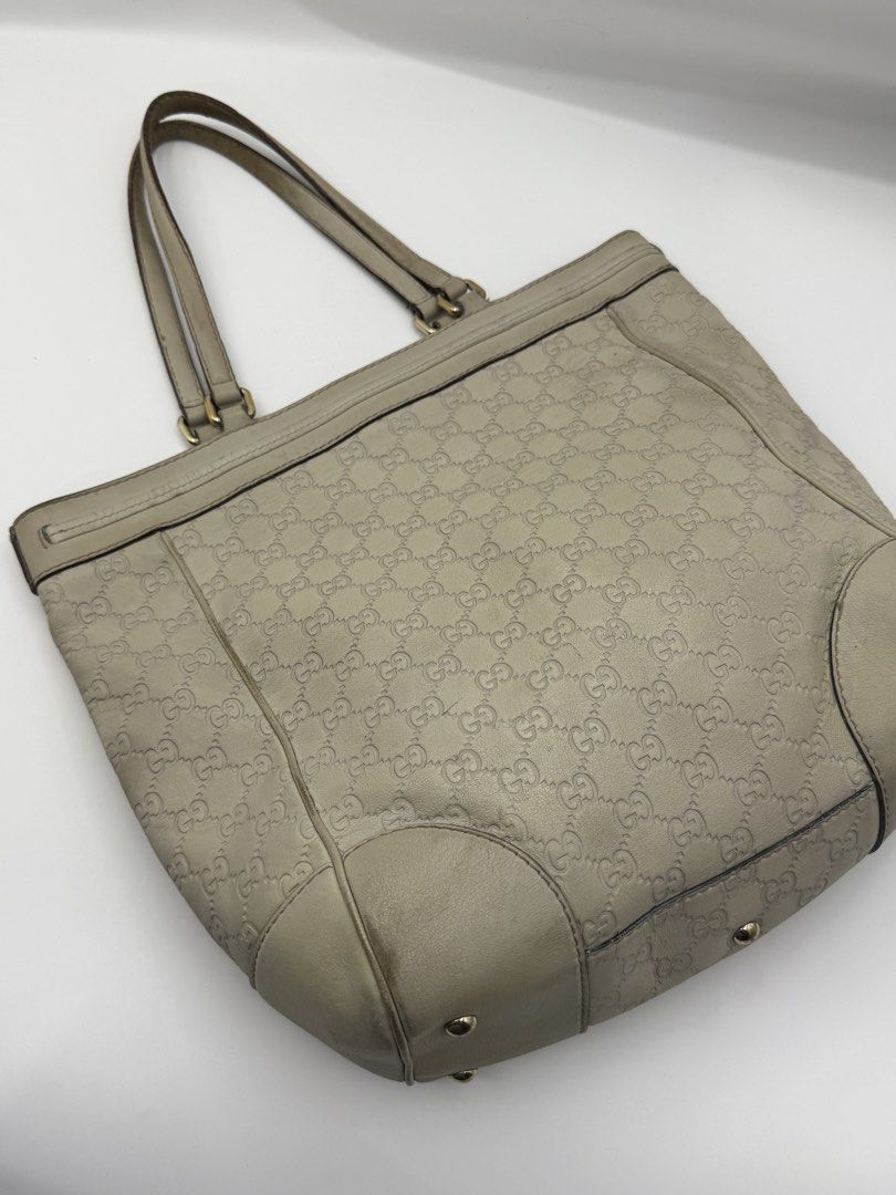 Gucci (Category: Shoulder Bags) located in Caloocan City. Submitted by rossvault2 (Listing ID 1465233015, Image 3). Description: Authentic Gucci tote bag in off-white leather. Iconic GG Guccissima monogram embossed all over. Double shoulder straps with gold-tone hardware. Cute little leather bow accent with a tiny metal GG logo near the top. Protective metal feet on the bottom. Spacious interior for daily essentials. Some minor scuffs and discolo