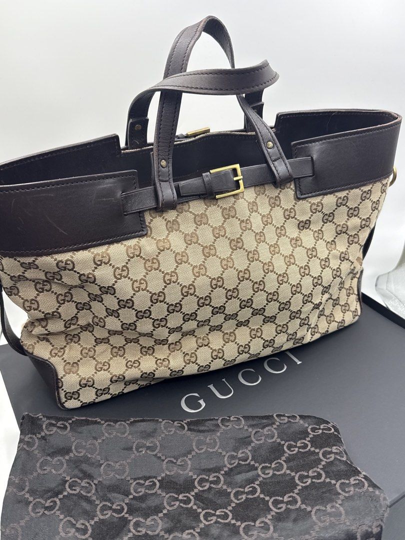 Gucci bag (Category: Shoulder Bags) located in Caloocan City. Submitted by rossvault2 (Listing ID 1465228503, Image 2). Description: - Authentic classic Gucci monogram canvas tote bag - Dark brown leather trim and sturdy top handles - Elegant gold-tone hardware buckle accent on the front - Spacious dark fabric interior with a secure zippered pocket - box not included - Crafted in Italy with official leather brand tag -needs cleaning.