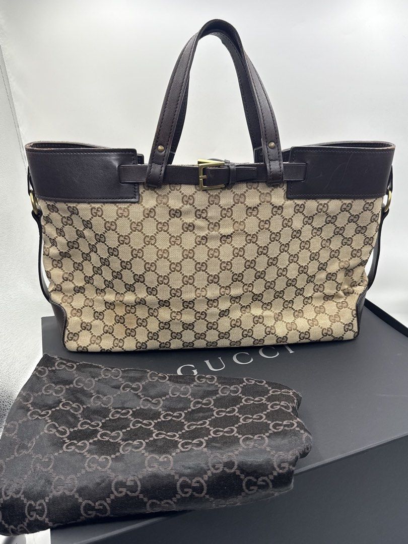 Gucci bag (Category: Shoulder Bags) located in Caloocan City. Submitted by rossvault2 (Listing ID 1465228503, Image 3). Description: - Authentic classic Gucci monogram canvas tote bag - Dark brown leather trim and sturdy top handles - Elegant gold-tone hardware buckle accent on the front - Spacious dark fabric interior with a secure zippered pocket - box not included - Crafted in Italy with official leather brand tag -needs cleaning.