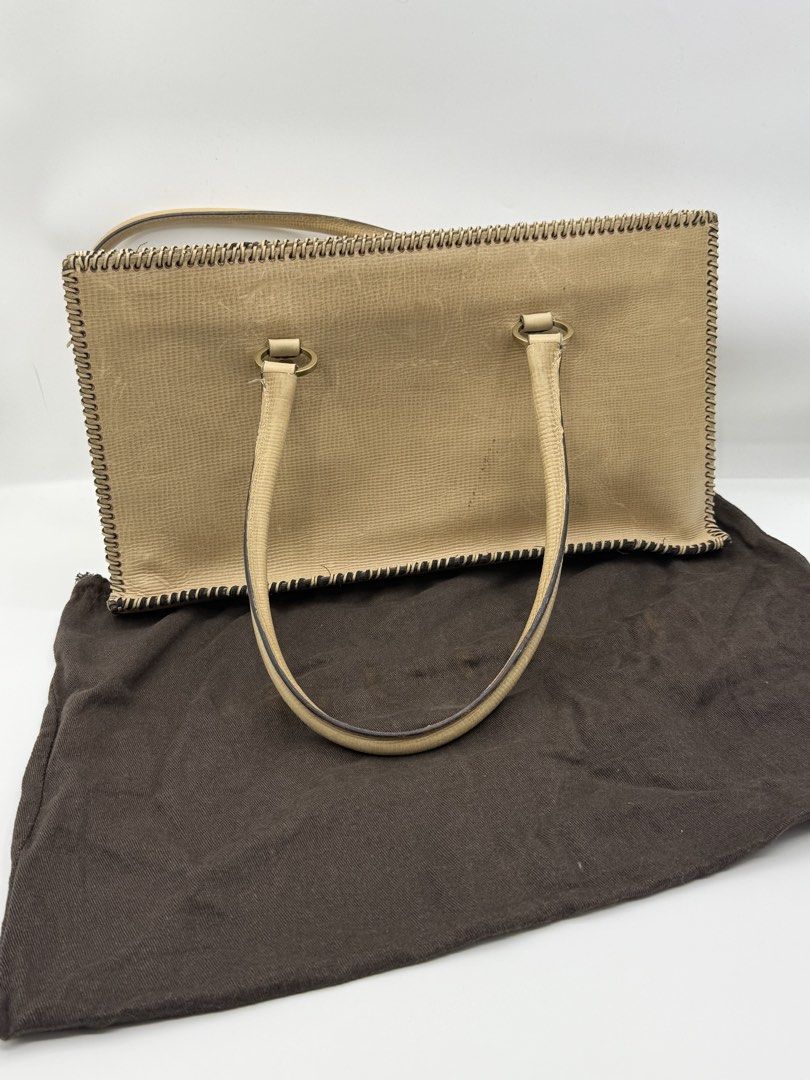 Gucci Beige Leather Tote Bag (Category: Shoulder Bags) located in Caloocan City. Submitted by rossvault2 (Listing ID 1465233228, Image 2). Description: Beige textured leather tote bag from Gucci. Double shoulder straps with metal ring connectors. Open top design with contrasting whipstitch edge detailing. Black fabric interior lining featuring the GG logo pattern with a center divider compartment. Includes original brown dust bag. -normal signs o