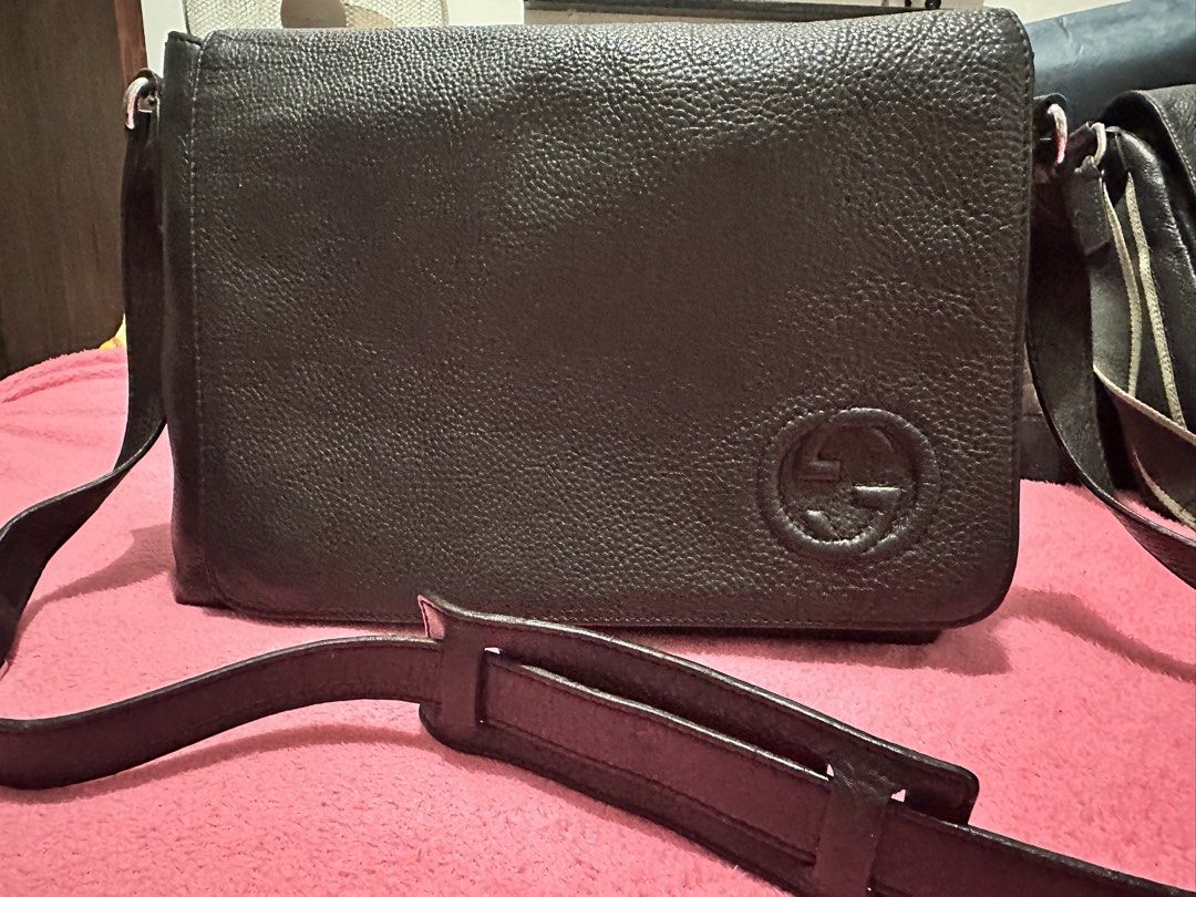Gucci Black Leather Messenger Bag (Category: Sling Bags) located in Quezon City. Submitted by pongoy (Listing ID 1465283164, Image 1). Description: - Brand: Gucci - Style: Black leather messenger bag with flap closure - Strap: Adjustable for comfortable wear - Exterior: Supple grained leather with embossed interlocking G logo - Interior: Clean cream canvas lining with a secure zipper pocket - Authenticity: Includes leather brand tag ("Gucci / mad