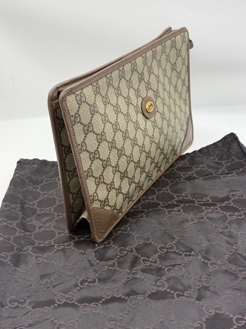 Gucci GG Monogram Clutch Bag (Category: Clutches) located in Caloocan City. Submitted by rossvault2 (Listing ID 1465235396, Image 2). Description: - Authentic vintage Gucci clutch in classic GG supreme canvas - Brown leather trim and corner accents with gold-tone hardware - Front interlocking G logo medallion and custom Gucci charm zipper pull - Structured shape with clean corners and smooth zipper runner - Includes matching dark brown monogram d
