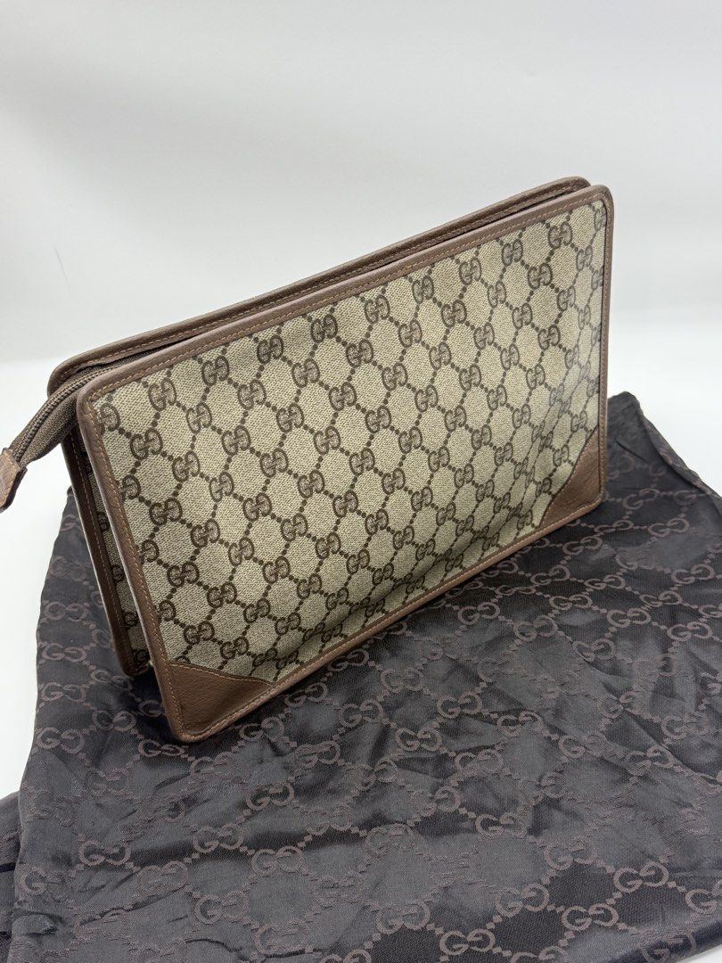Gucci GG Monogram Clutch Bag (Category: Clutches) located in Caloocan City. Submitted by rossvault2 (Listing ID 1465235396, Image 3). Description: - Authentic vintage Gucci clutch in classic GG supreme canvas - Brown leather trim and corner accents with gold-tone hardware - Front interlocking G logo medallion and custom Gucci charm zipper pull - Structured shape with clean corners and smooth zipper runner - Includes matching dark brown monogram d