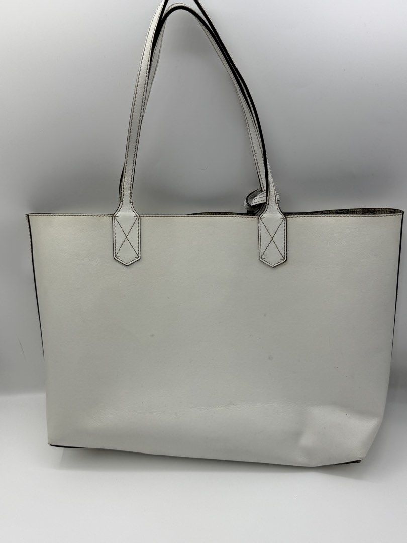 Gucci White Reversible Leather Tote Bag (Category: Tote Bags) located in Caloocan City. Submitted by rossvault2 (Listing ID 1465232736, Image 3). Description: - Gucci white leather tote bag - Reversible design with classic GG monogram fabric interior - Features comfortable dual shoulder straps and matching embossed logo hanging tag - Spacious interior, perfect as an everyday carryall - Condition: Shows visible marks and smudges on the exterior wh