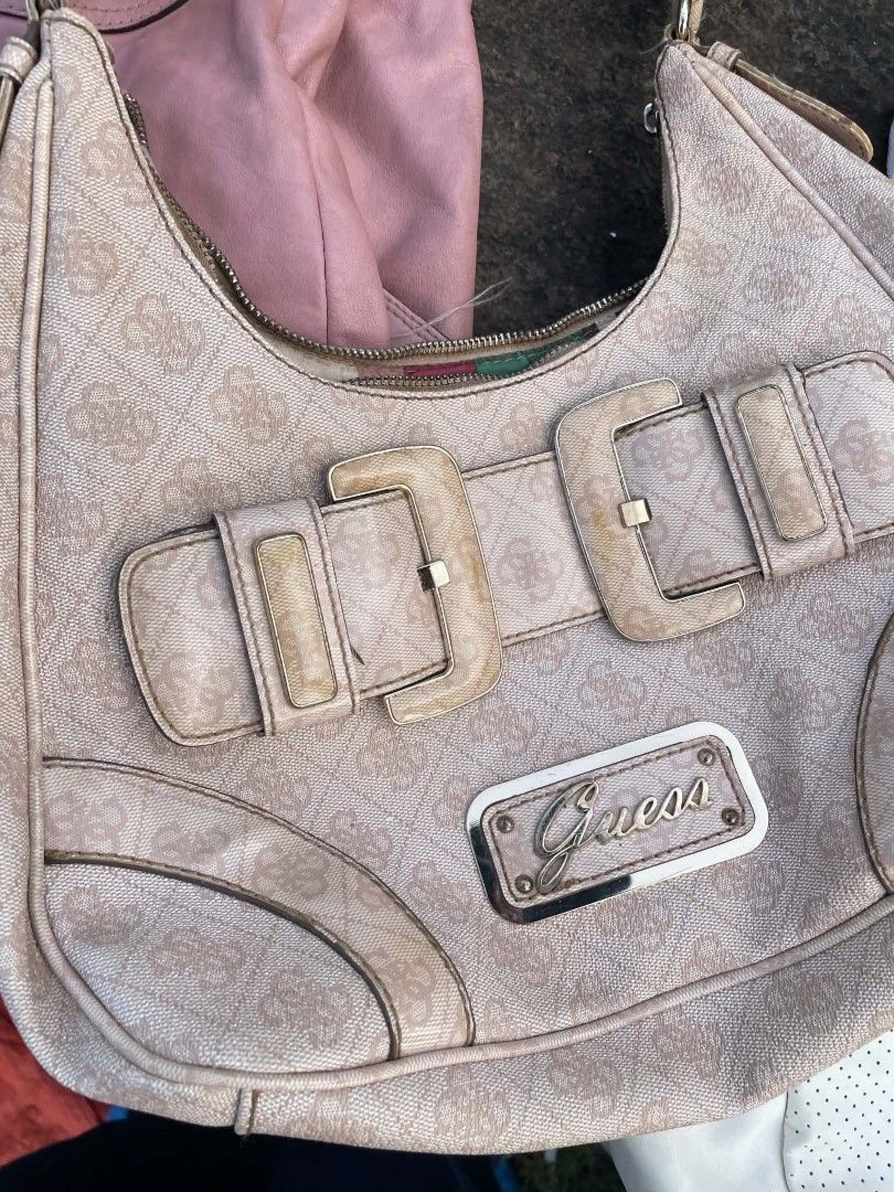 Guess Monogram Shoulder Bag with Buckle Detail (Category: Shoulder Bags) located in Cainta. Submitted by riszizlux (Listing ID 1465269892, Image 2). Description: - Brand: Guess - Color/Design: Pink monogram print with silver-tone hardware - Exterior: Two buckle accents on the front, metal logo plate, and a back zip pocket - Closure: Secure top zipper closure - Strap: Matching monogram shoulder strap with an adjustable buckle - Interior: Roomy spa