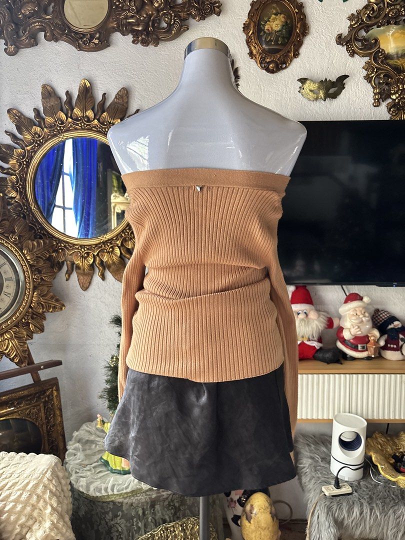 Guess Ribbed Knit Sweater (Category: Longsleeves) located in Batangas. Submitted by lilirosie (Listing ID 1465192635, Image 3). Description: - Brand: Guess - Color: Camel brown - Style: Off-shoulder ribbed knit sweater with long sleeves - Details: Decorative gold-tone front buttons and iconic metal Guess triangle logo plaque on the back - Fit: Stretchy and comfortable - Versatility: Neutral shade that matches effortlessly with skirts, denim, or t