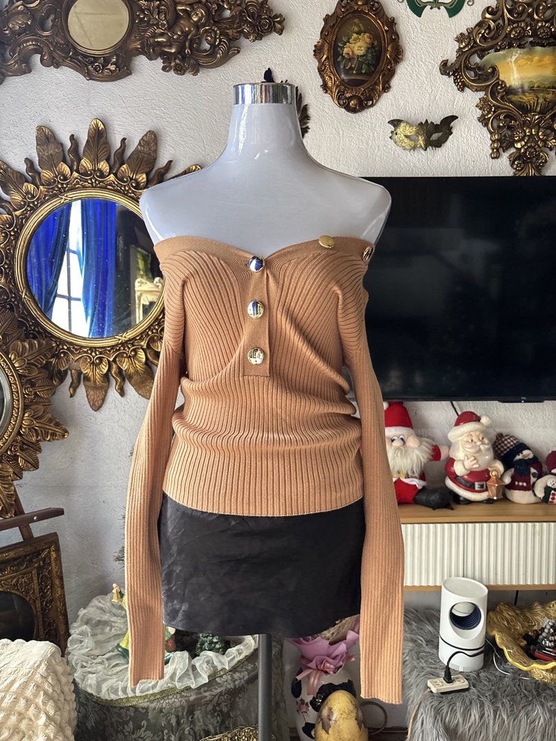 Guess Ribbed Knit Sweater (Category: Longsleeves) located in Batangas. Submitted by lilirosie (Listing ID 1465192635, Image 1). Description: - Brand: Guess - Color: Camel brown - Style: Off-shoulder ribbed knit sweater with long sleeves - Details: Decorative gold-tone front buttons and iconic metal Guess triangle logo plaque on the back - Fit: Stretchy and comfortable - Versatility: Neutral shade that matches effortlessly with skirts, denim, or t