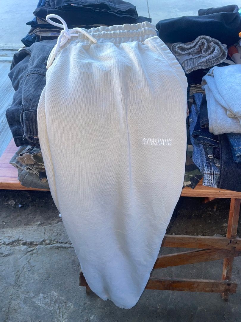 Gymshark Beige Sweatpants Size L (Category: Joggers) located in Puerto Princesa. Submitted by bestthrift123 (Listing ID 1465256029, Image 2). Description: - Brand: Gymshark - Color: Beige - Size: Large - Material: Soft fabric (Made in Bangladesh) - Design: Elastic waistband with white drawstring, white Gymshark logo on left thigh, and cuffed ankles - Fit/Usage: Comfortable fit, ideal for workouts or lounging.
