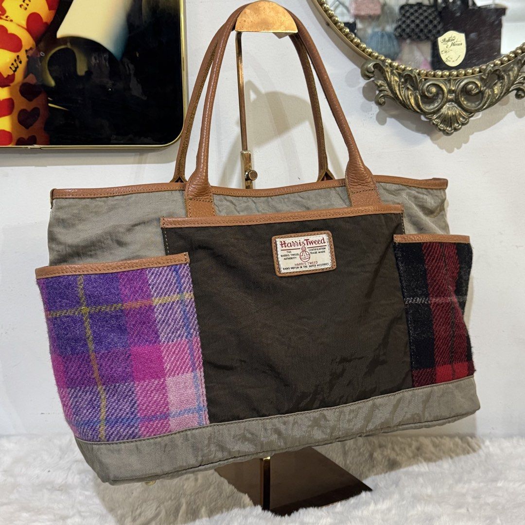 Harris Tweed Patchwork Tote Bag Brown Purple Plaid (Category: Tote Bags) located in Rizal. Submitted by houseofbell (Listing ID 1465374504, Image 2). Description: - Authentic Harris Tweed tote bag with official orb label - Brown main body with stylish green-tinted canvas panels - Unique side slip pockets in purple-pink and red-black wool plaid - Premium leather handles, trim, and large front pocket - Protective metal feet on the bottom base Dimen