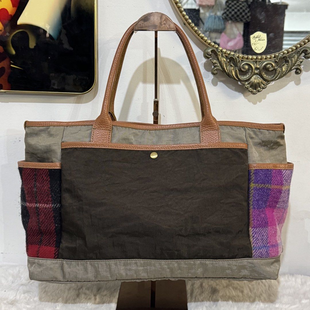 Harris Tweed Patchwork Tote Bag Brown Purple Plaid (Category: Tote Bags) located in Rizal. Submitted by houseofbell (Listing ID 1465374504, Image 3). Description: - Authentic Harris Tweed tote bag with official orb label - Brown main body with stylish green-tinted canvas panels - Unique side slip pockets in purple-pink and red-black wool plaid - Premium leather handles, trim, and large front pocket - Protective metal feet on the bottom base Dimen