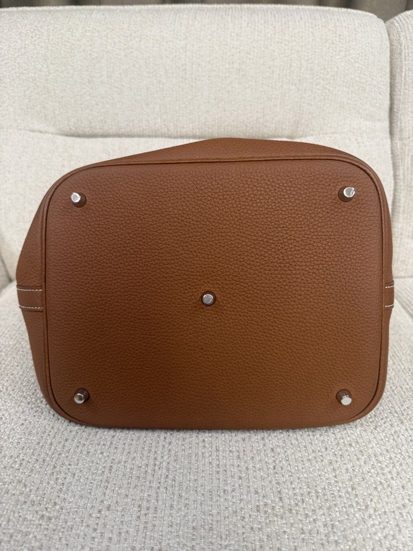 Hermes Picotin Lock 26 Taurillon Clemence Gold (Category: Luxury Bags & Wallets) located in Makati City. Submitted by dgcurated09 (Listing ID 1465366389, Image 3). Description: - Color: Tan - Material: Textured grained leather with natural suede interior - Hardware: Silver-toned metal with protective feet on a structured flat base - Handles: Two top handles featuring stylish white contrast stitching - Closure: Center strap with a secure silver bu