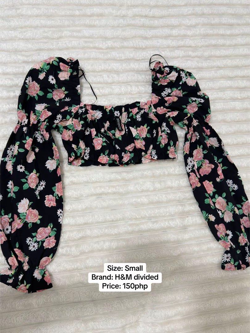 H&M Divided Floral Crop Top Small (Category: Sleeveless) located in Pasig City. Submitted by jamie.sebuc (Listing ID 1465237754, Image 1). Description: - Style: Cottagecore / Casual Weekend - Design: Black crop top with all-over pink rose and white daisy print - Features: Long balloon sleeves, square neckline, smocked hem, and thin shoulder straps - Material: Lightweight and comfortable fabric.