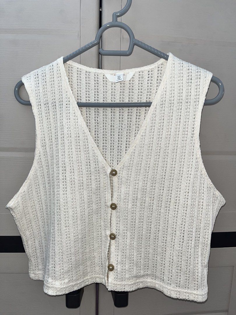 H&M Knit Cropped Vest (Category: Sleeveless) located in Caloocan City. Submitted by yukiipatootie_ (Listing ID 1465207258, Image 1). Description: - Brand: H&M - Size: EUR L on tag - Fit for small and medium fram - DM FOR WHEN WORN - Color: Cream - Style: V-neck sleeveless knit vest with front tortoiseshell buttons - Texture: Chunky textured weave pattern - Condition: Great for layering or wearing on its own.