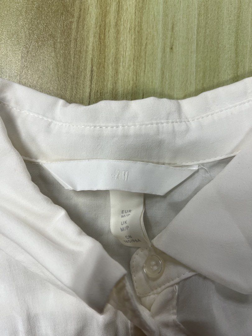 H&M White Button-Up Short Sleeve Blouse Size M (Category: Blouses) located in Manila. Submitted by issie_07 (Listing ID 1465212179, Image 2). Description: - Brand: H&M - Size: M - Color: Classic White - Fit: Relaxed, loose fit with short sleeves - Details: Classic collar, front button closure, and soft lightweight fabric with shoulder gathering - Condition: Excellent / Well-maintained - Perfect for: Office wear, smart-casual outfits, and everyday