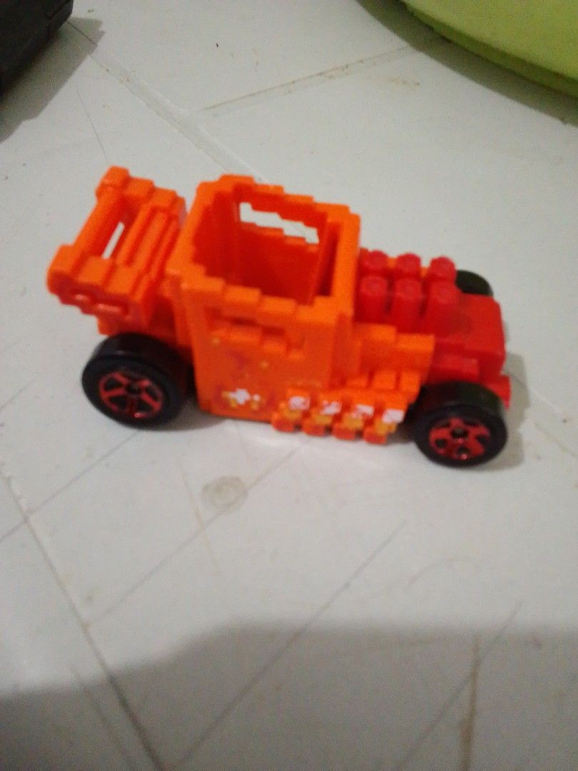 Hot Wheels Pixel Shaker Orange Toy Car (Category: Vehicle & Diecast Models) located in Quezon City. Submitted by zealstone_baf57c (Listing ID 1465244947, Image 1). Description: - Model: Hot Wheels Pixel Shaker - Color: Bright orange with pixel-style brick design - Details: Red front engine and black wheels - Era: 2019 Mattel stamp on black base - Origin: Made in Malaysia - Condition: Compact toy vehicle with solid rolling wheels.