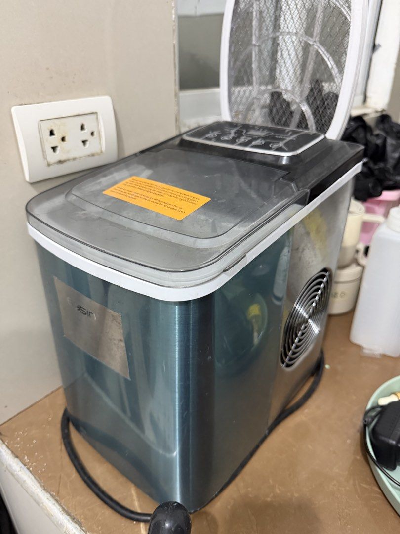 Ice Maker Machine (Category: Refrigerators and Freezers) located in Manila. Submitted by happybear_6d208c (Listing ID 1465342897, Image 2). Description: Eysin electric ice maker in teal and black. Digital control panel on top with settings for timer, clean, on/off, and ice size. Clear lid includes an instruction sticker about first-time use. Built-in cooling fan vent on the side. Standard power cord attached. Works great for quick ice at home..