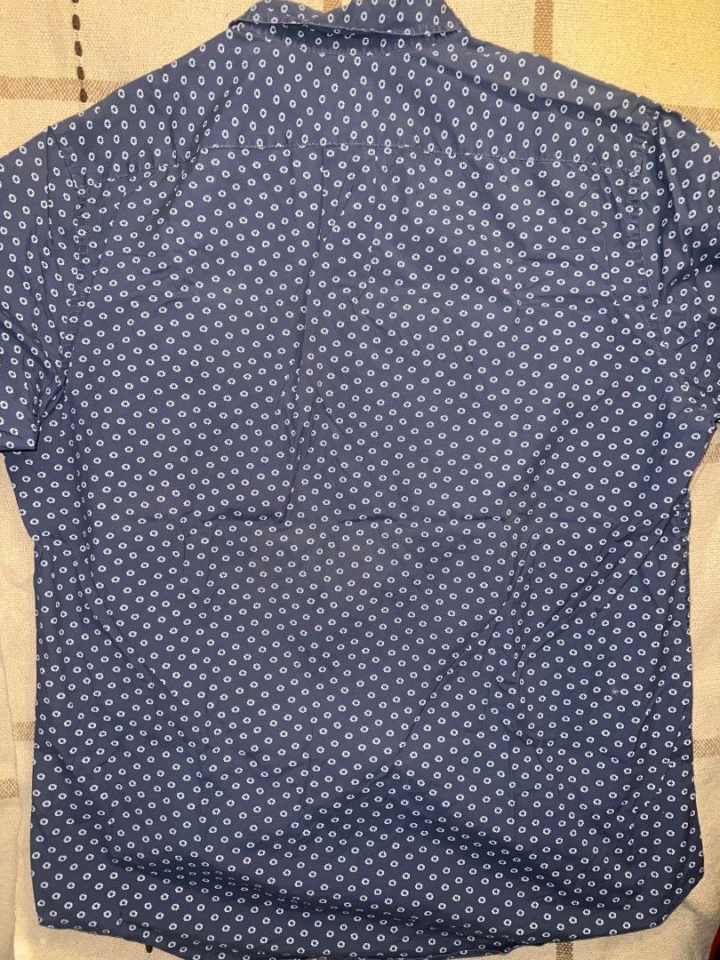 j.crew Classic Blue Patterned Button-Down Shirt Size M (Category: Tshirts & Polo Shirts ) located in Manila. Submitted by allyionia (Listing ID 1465208662, Image 3). Description: - Brand: J.Crew - Size: Medium - Color/Pattern: Blue with small white floral all-over print - Fit: Classic fit with stretch fabric - Material: Organic cotton - Features: Single chest pocket, button-front closure, button-down collar - Condition: Clean and ready to wear.