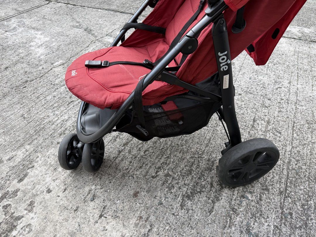 Joie red baby stroller with basket (Category: Strollers) located in Las Pinas. Submitted by lesleyann162961 (Listing ID 1465224827, Image 2). Description: - Brand: Joie - Color: Vibrant red with sleek black frame and wheels - Sun Protection: Large canopy to shield baby from the sun - Storage: Roomy under-seat basket for diaper bags and essentials - Safety: Secure harness keeps your little one safely buckled in - Comfort: Comfortable foam grip han