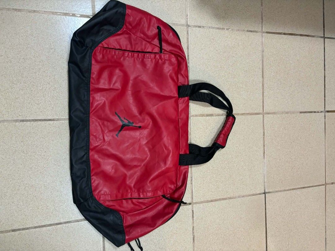 Jordan Red and Black Duffel Bag (Category: Sling Bags) located in Caloocan City. Submitted by joshuadyogi0122 (Listing ID 1465181737, Image 1). Description: - Authentic Jordan duffel bag in a classic red and black colorway - Iconic Jumpman logo printed prominently on the front - Spacious main compartment with 100% polyester lining - Convenient zippered front pocket for quick-access items - Dual carrying handles equipped with a padded grip for ext