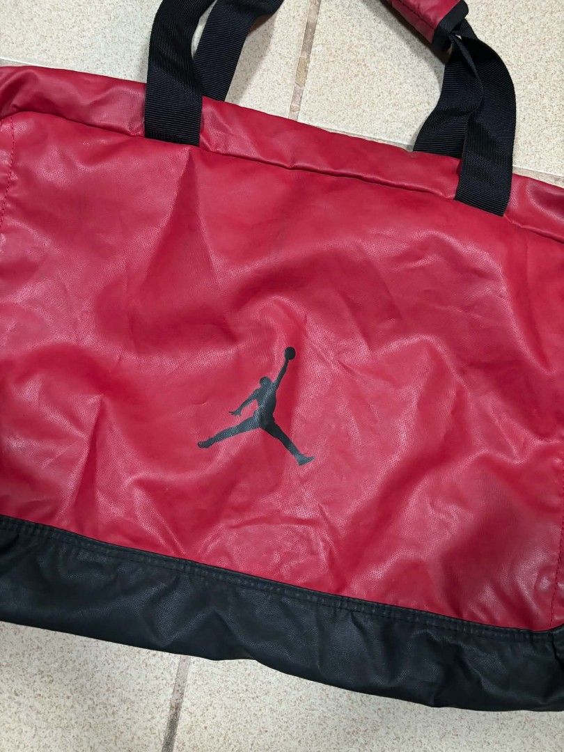 Jordan Red and Black Duffel Bag (Category: Sling Bags) located in Caloocan City. Submitted by joshuadyogi0122 (Listing ID 1465181737, Image 3). Description: - Authentic Jordan duffel bag in a classic red and black colorway - Iconic Jumpman logo printed prominently on the front - Spacious main compartment with 100% polyester lining - Convenient zippered front pocket for quick-access items - Dual carrying handles equipped with a padded grip for ext