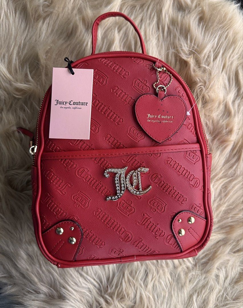 Juicy Couture No Rules Backpack Cool Red (Category: Backpacks) located in Cavite. Submitted by kkollections2023 (Listing ID 1465176869, Image 1). Description: - Brand new with original store tag attached (Retail: $99) - Eye-catching bright red color with all-over debossed logo and crown graphics - Sparkling rhinestone-studded JC monogram emblem on the front pocket - Includes a trendy heart-shaped logo mirror charm attached to the strap - Features