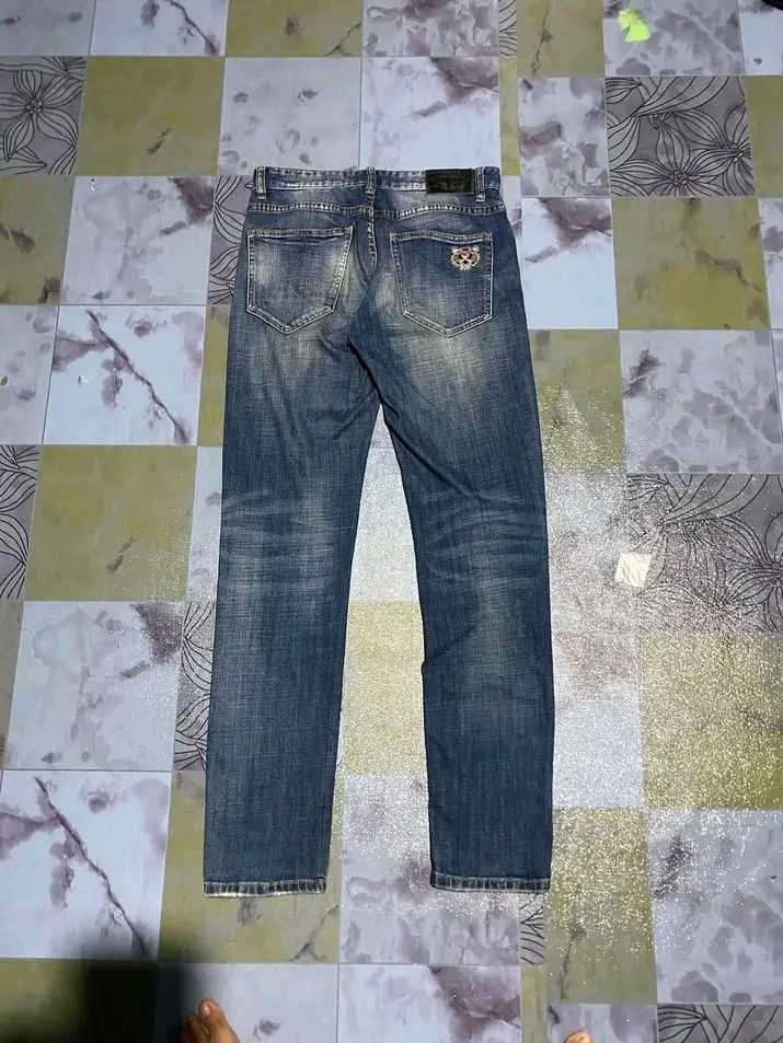 Kenzo Paris Jungle Distressed Denim Jeans (Category: Jeans) located in Manila. Submitted by bright.mayess (Listing ID 1465373563, Image 1). Description: - Brand: Kenzo Paris (Jungle line) - Style: Slim fit distressed denim jeans in blue wash - Design: Signature tiger patch on the back pocket with branded inner waistband tags - Material: 100% premium cotton - Condition: Excellent, unique statement piece.