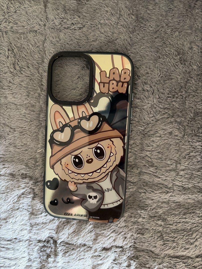 Labubu IPHONE 16 case (Category: Cases & Sleeves) located in Manila. Submitted by rich028 (Listing ID 1465224916, Image 1). Description: - Compatible Model: iPhone 16 - Design: Cute and trendy Labubu character wearing a hat with heart-shaped glasses and cool graphic details - Protection: Durable black shockproof bumper edges and raised camera protection - Finish: Glossy/reflective backing with 'COOLARMOR DESIGN' accent - Condition: Layered condit