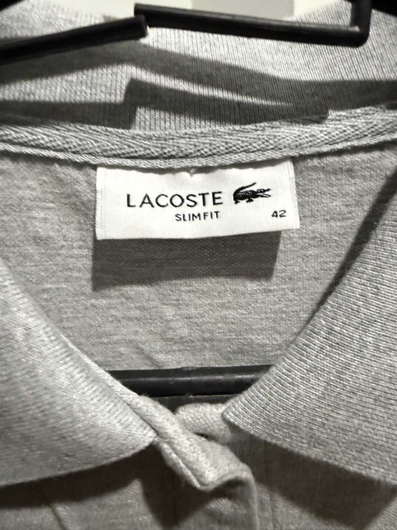 Lacoste Polo Dress (Category: Dresses) located in Mandaluyong City. Submitted by whitemoveout (Listing ID 1465325310, Image 3). Description: - Brand: Lacoste ORIGINAL - Style: Slim fit polo dress - Color: Grey - Size: 42 (Tag on collar) - Material: Soft cotton blend with interior care tags intact - Details: Full button placket with matching buttons, classic polo collar, and short sleeves - Branding: Iconic green crocodile logo embroidered on the 
