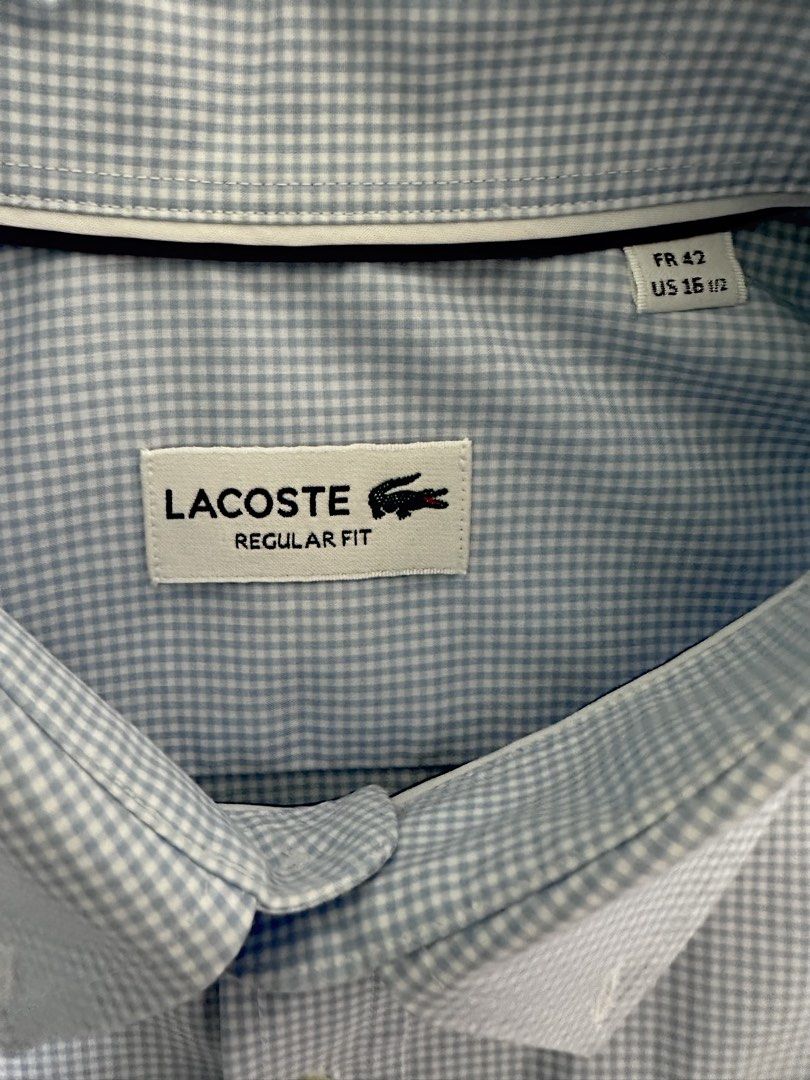Lacoste Regular Fit Gingham Long Sleeve Shirt (Category: Formal Shirts) located in Quezon City. Submitted by aussomefinds (Listing ID 1465361567, Image 2). Description: - Brand: Lacoste - Style: Long sleeve button-up shirt in light blue and white gingham check - Fit: Regular fit with a classic collar and single-button cuffs - Details: Features the iconic embroidered green crocodile logo on the chest - Size: Tagged FR 42 / US 15.5 - Condition: Exc