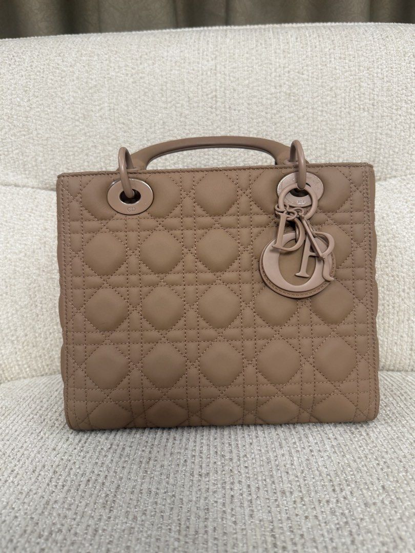 Lady Dior Medium (Category: Luxury Bags & Wallets) located in Makati City. Submitted by dgcurated09 (Listing ID 1465219225, Image 1). Description: - Authentic Taupe Lady Dior bag - Classic Cannage quilting with matte finish hardware - Elegant tonal dangling charms - Dual top handles and adjustable leather shoulder strap - Luxurious suede interior with a convenient divider pocket - Clean and structured overall shape.