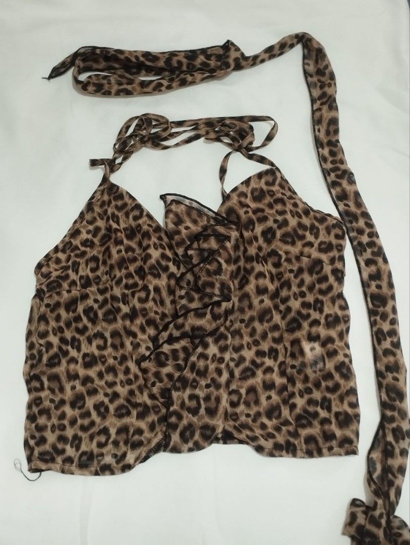 Leopard Print Halter Top with Choker Detail (Category: Sleeveless) located in Manila. Submitted by nicole_alega (Listing ID 1465218192, Image 2). Description: - Style: Leopard print halter top with a matching attached choker - Details: Deep V-neckline and cute ruffled hem at the front - Material: Lightweight, silky smooth fabric - Condition: Worn only once for a quick photo, like new - Styling tip: Pairs effortlessly with your favorite blue jeans