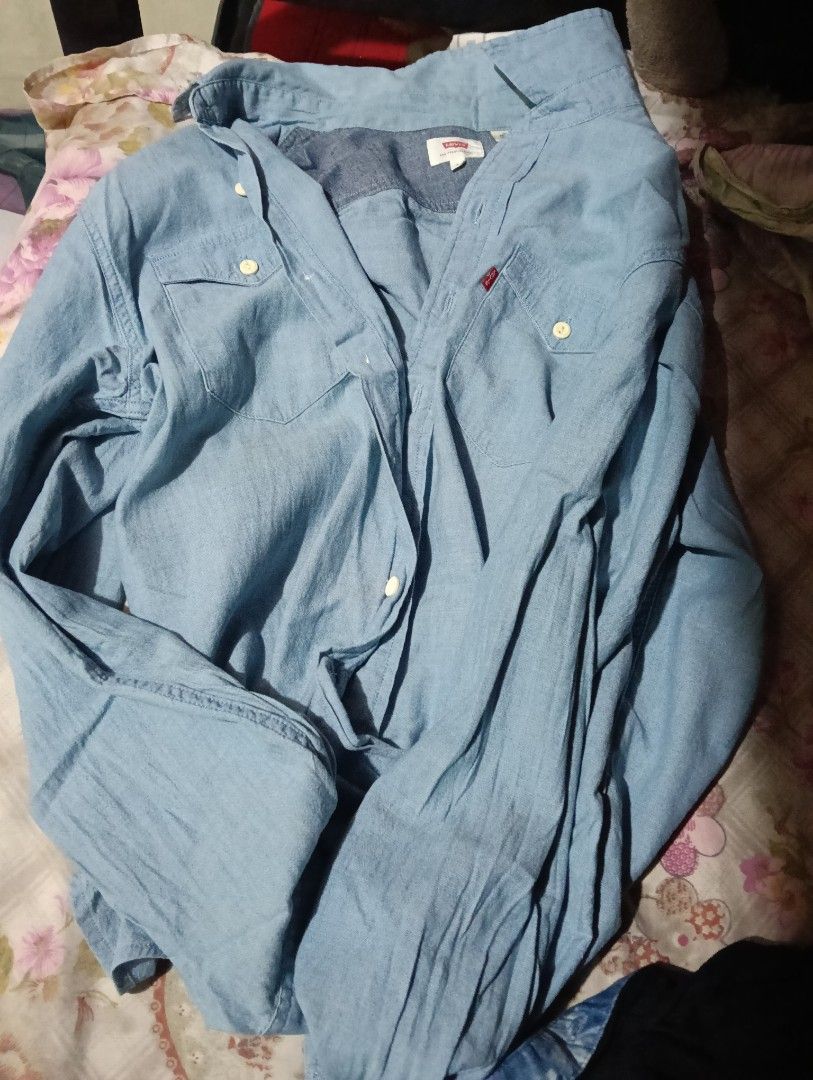 Levi's Light Blue Denim Button-Down Long Sleeve Shirt (Category: Longsleeves) located in Manila. Submitted by rakelherms (Listing ID 1465311609, Image 1). Description: - Brand: Levi's - Color: Light blue denim - Fit: Standard fit - Details: Long sleeves, front button closure, classic collar - Pockets: Double chest pockets with button flaps - Style: Casual wardrobe staple, perfect for layering or wearing solo.